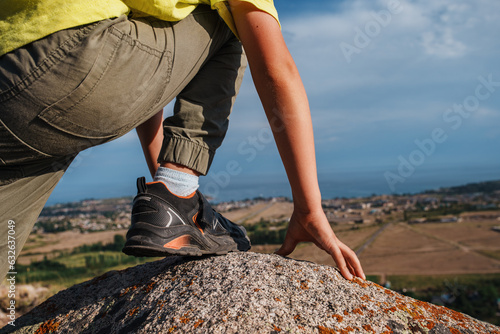 Photography Boy hiker standing on top of a mountain on lake background, boots close-up view