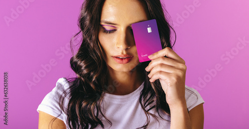 Woman in her 20s holding an exclusive purple credit card in her hand