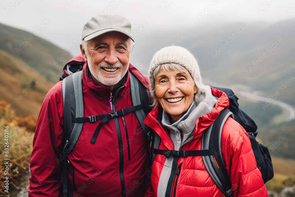 Candid portrait of a happy smiling elderly couple in love, hiking in the mountains - outdoor activities and active lifestyle
