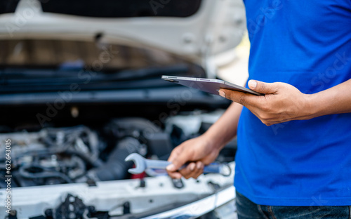 Automotive mechanic repairmen use tablets and check the system working engine of the engine room, check the mileage of the car, oil change, auto maintenance service concept. © sirichai