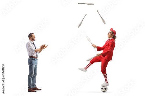 Full length profile shot of a man giving an applause and watching a guy juggling