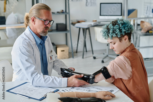 Portrait of young woman with blue hair during arm prosthetic fitting in orthology clinic