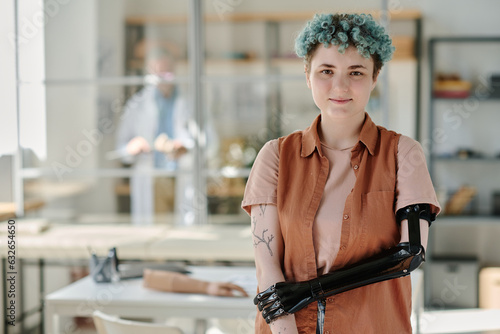 Tableau sur toile Waist up portrait of young woman with bionic prosthetic arm posing in doctors of