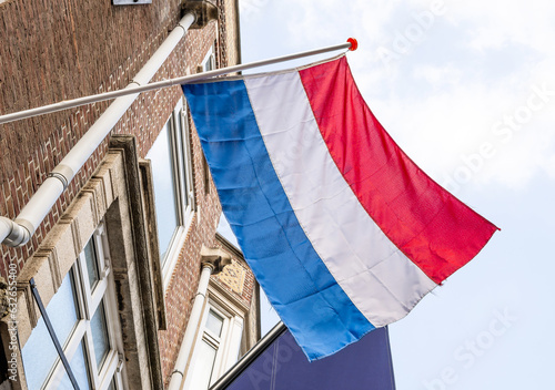 Netherlands flag on fasad building against Blue Sky in