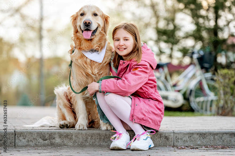 Girl with golden retriever dog outdoors in sunny day portrait. Female child kid hugging pet doggy labrador at street Girl with golden retriever dog outdoors in sunny day portrait. Female child kid hugging pet doggy labrador at street