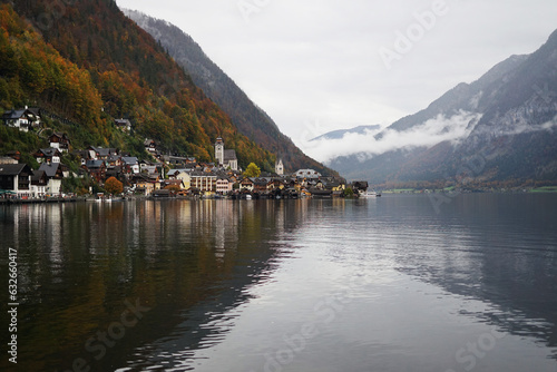 View of a small town with a church against the backdrop of mountains and a large lake on a cloudy autumn day  © Kateryna