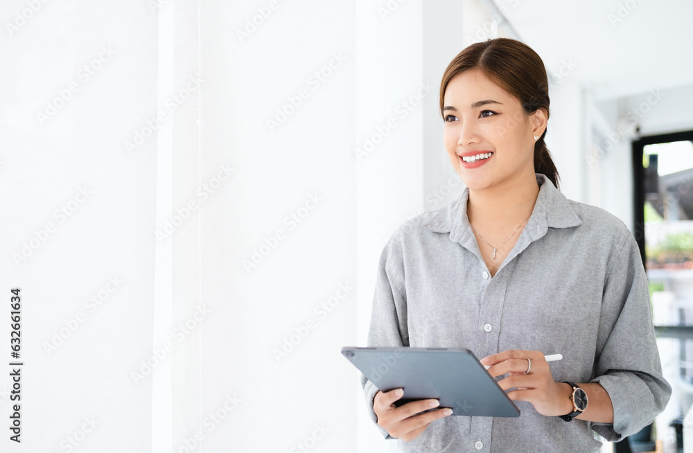 Thinking about how to take the business to technological heights. attractive cheerful young businesswoman working in her office. Thinking about how to take the business to technological heights. attractive cheerful young businesswoman working in her office.