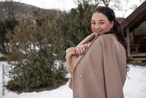 Beautiful woman wearing the coat, sweater and  jeans , the girl in warm cothes. Plus size  modelk waking in snow day in the winter nature photo