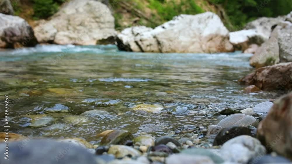 hiker steps into the water on the bank of a mountain river. splashes fly from trekking shoes. close-up shot. hiker steps into the water on the bank of a mountain river. splashes fly from trekking shoes. close-up shot.