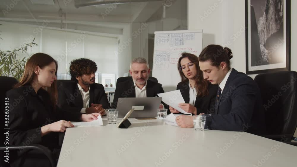 The investor team sitting in the conference room is holding an emergency meeting. Business partners check documents before signing a new contract. The investor team sitting in the conference room is holding an emergency meeting. Business partners check documents before signing a new contract.