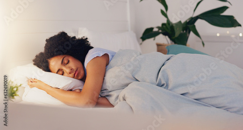 Obraz na płótnie Young black woman sleeping in bed in her bedroom while resting and having a dream at home