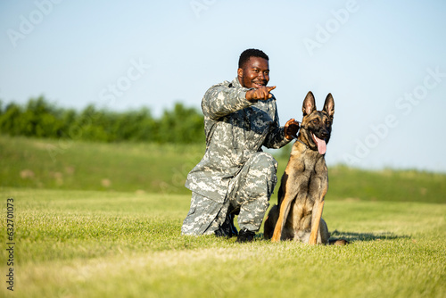 Soldier giving a command to his military dog at training camp.