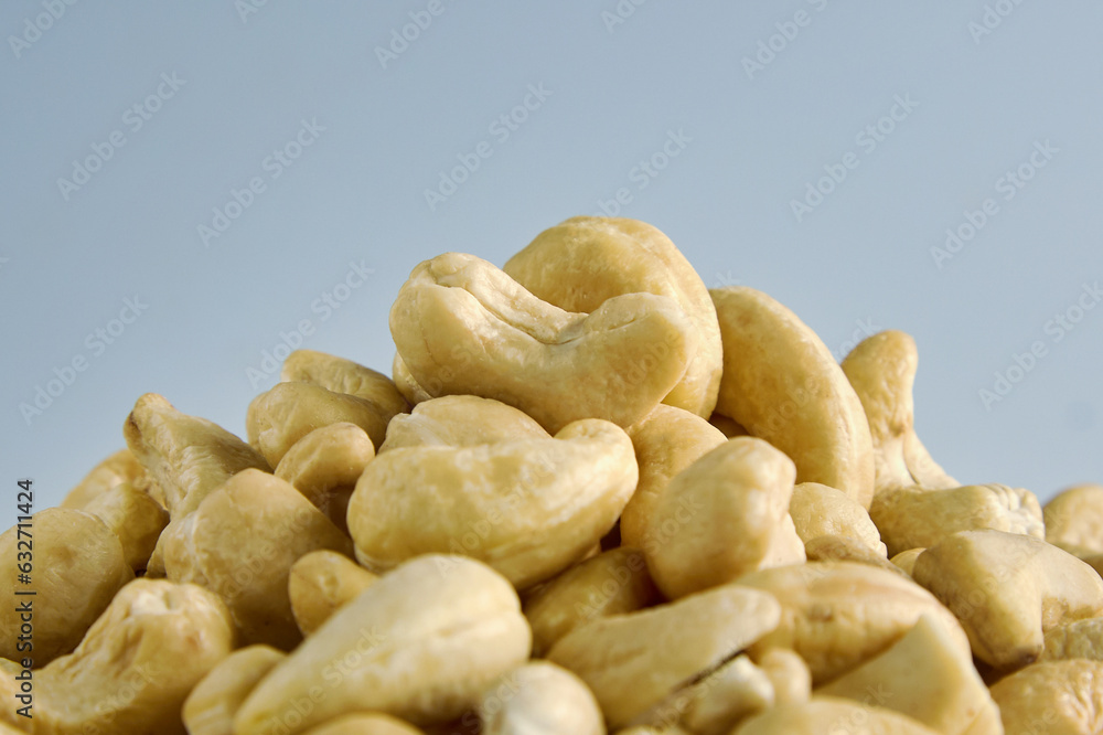 Large pile of cashew nuts close-up on white background. Packaging design element. Delicious crunchy cashew nuts in close-up laid out in a heap Large pile of cashew nuts close-up on white background. Packaging design element. Delicious crunchy cashew nuts in close-up laid out in a heap
