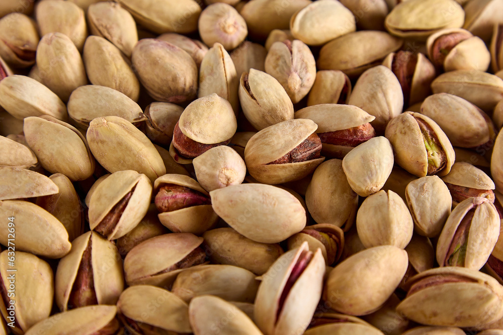 Delicious, mouth-watering fried pistachios in a shell as a background. Close-up of healthy pistachios in a cracked shell, taken from above Delicious, mouth-watering fried pistachios in a shell as a background. Close-up of healthy pistachios in a cracked shell, taken from above