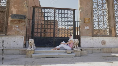 Woman is sitting near on a stairs with old Arabic ornaments.  photo