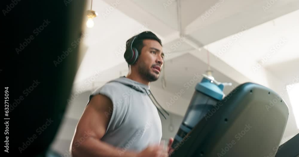 Fitness, watch and man on a treadmill with headphones at gym training for exercise. Profile of Asian athlete person listening to music for running, cardio time or workout on machine for health Fitness, watch and man on a treadmill with headphones at gym training for exercise. Profile of Asian athlete person listening to music for running, cardio time or workout on machine for health