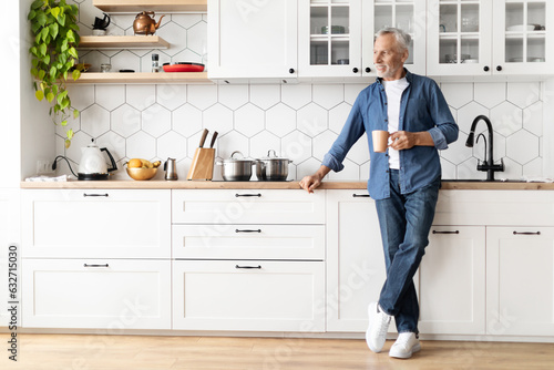 Happy Morning. Portrait Of Smiling Senior Man Drinking Coffee In Kitchen,