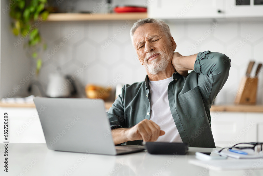 Tired Elderly Man Suffering Neck Pain After Working With Laptop At Home Tired Elderly Man Suffering Neck Pain After Working With Laptop At Home