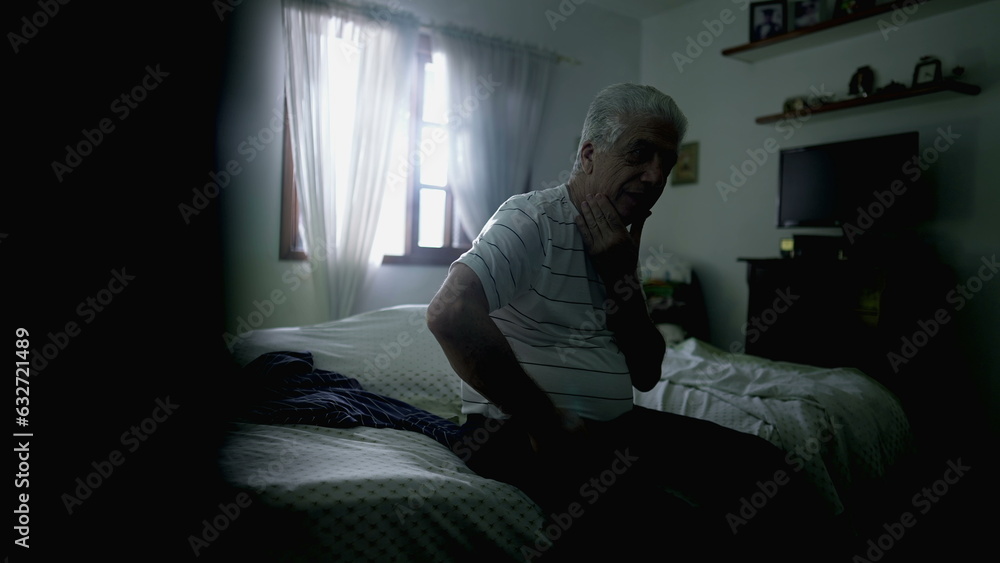 Thoughtful senior man pondering decision while sitting by bedside in somber room with hand in chin contemplating life in moody lonely scene Thoughtful senior man pondering decision while sitting by bedside in somber room with hand in chin contemplating life in moody lonely scene