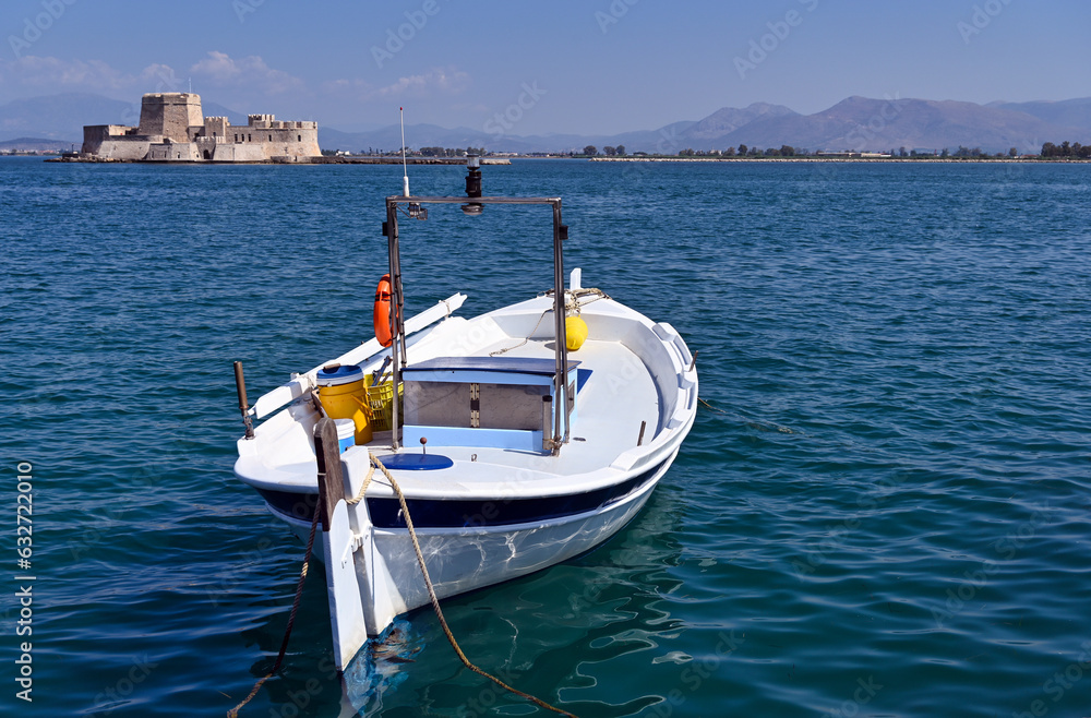 Small fishing boat and and Bourtzi fortress in Nafplio, Peloponnese, Greece