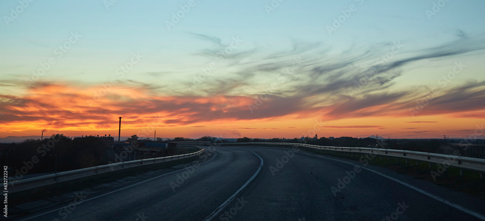 Beautiful sunset on the highway between the cities. Landscape with nature and clouds