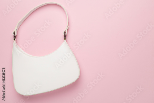 Trendy woman bag on color background, top view