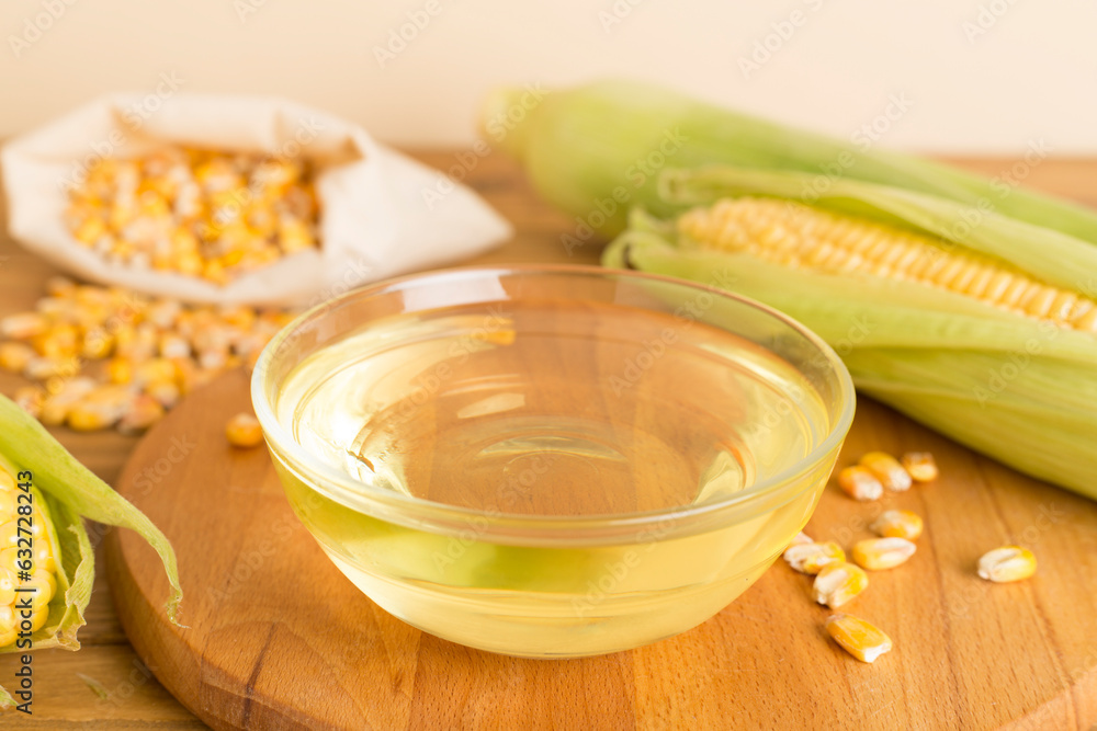 Corn oil with fresh cobs on wooden table Corn oil with fresh cobs on wooden table