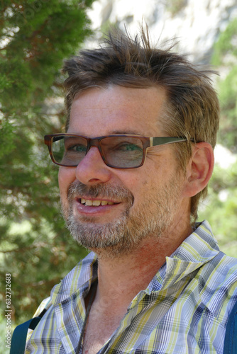 portrait outdoor of a mature bearded man with glasses 