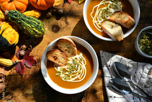Autumn harvest winter meal of butternut squash pumpkin soup with sour cream and pumpkin seeds bread