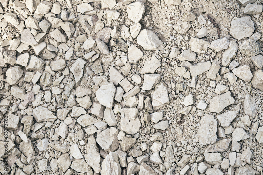 Road grave texture for background. White crushed stone. Top view of dirt road fragment. Dry land with stones. Road grave texture for background. White crushed stone. Top view of dirt road fragment. Dry land with stones.