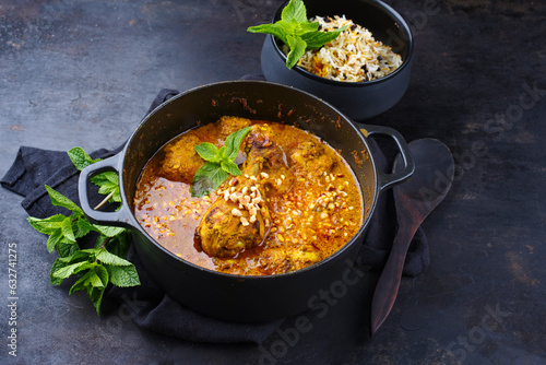 Traditional spicy Indian chicken Madras curry Rogan Josh with drumsticks and rice served as close-up in a Nordic design potl with copy space