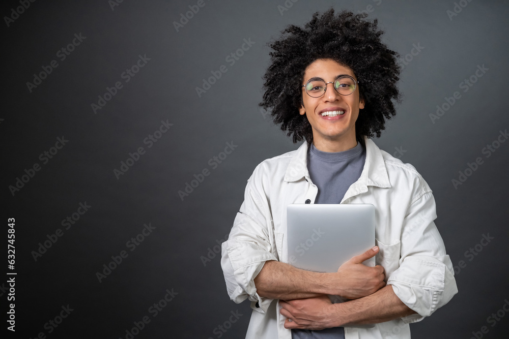 Young curly-haired digital nomad with a laptop in hands Young curly-haired digital nomad with a laptop in hands