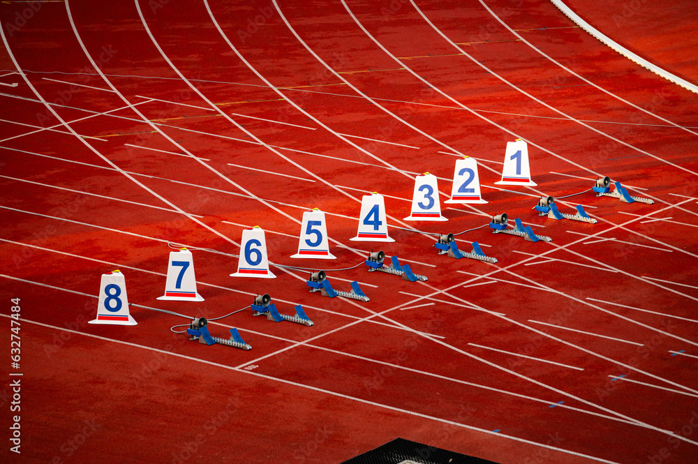 Start of sprint race. Numbers and starting blocks on the red track