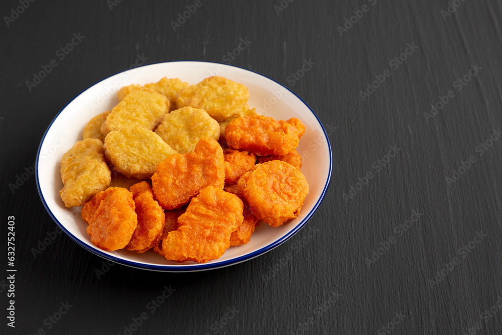 Homemade Spicy Chicken Nuggets Mix on black background, side view. Copy space. Homemade Spicy Chicken Nuggets Mix on black background, side view. Copy space.
