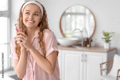 Young woman with razor in bathroom