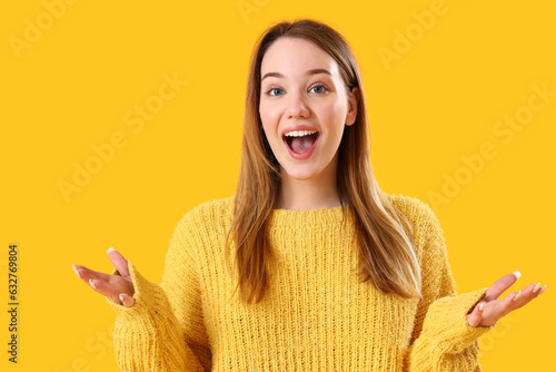 Happy young woman on yellow...