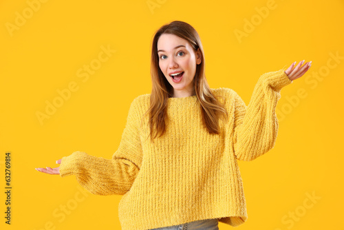 Happy young woman on yellow...