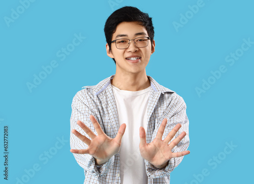 Young Asian man showing han...
