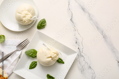 Plates with tasty Burrata cheese on white marble background