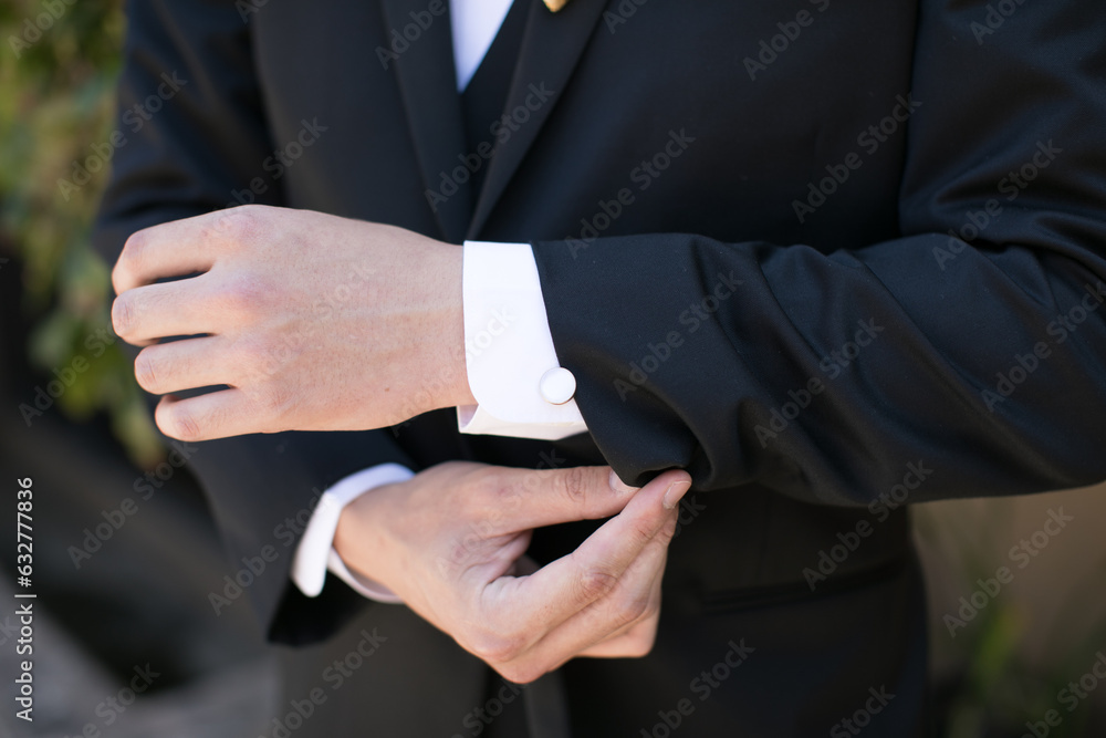 Obraz premium groom buttoning cufflinks
