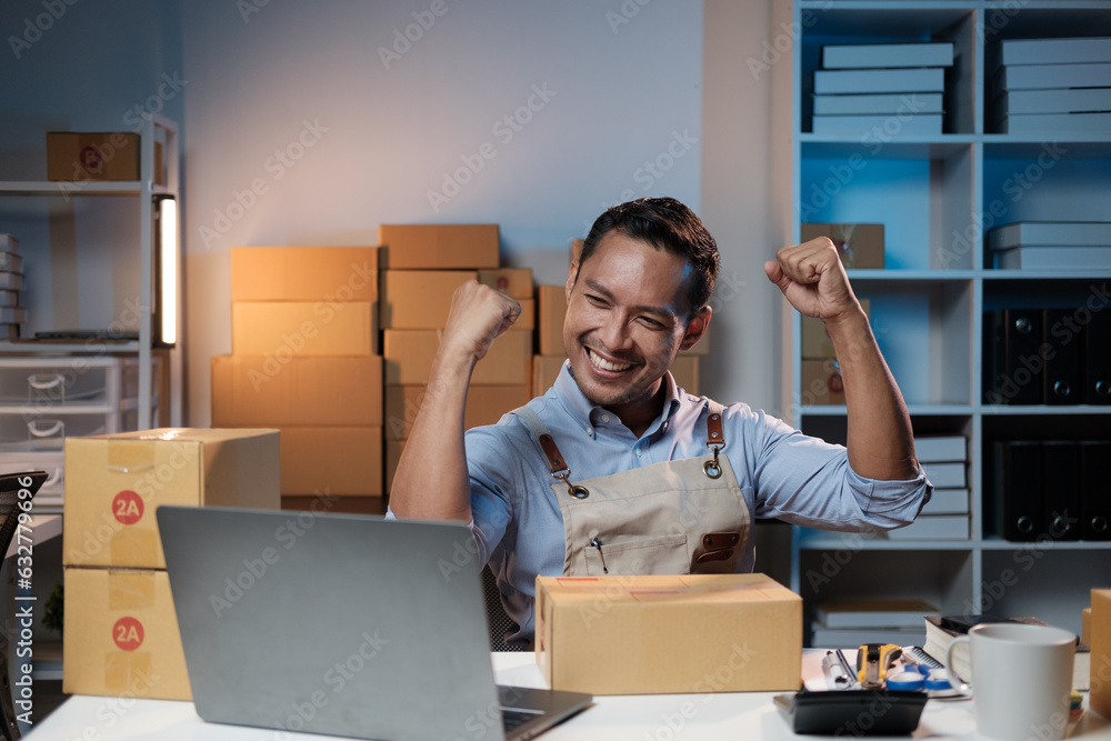 Successful Asian SME shop owner celebrating with his new highet sell, working during the night time at night. Successful Asian SME shop owner celebrating with his new highet sell, working during the night time at night.