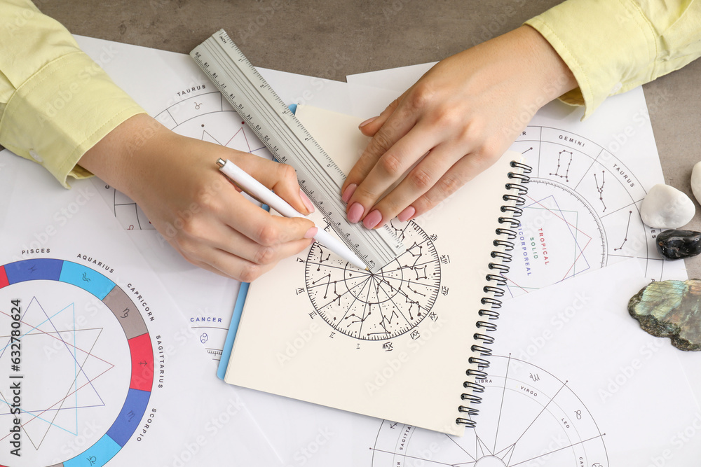 Astrologer using zodiac wheel for fate forecast at table, top view. Fortune telling Astrologer using zodiac wheel for fate forecast at table, top view. Fortune telling