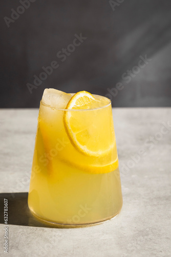 Homemade lemonade with ice and lemon slices in a glass.