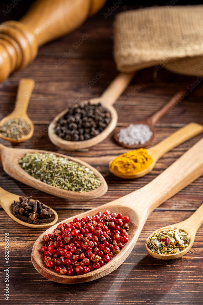 Various spices and seasonings in wooden spoons.