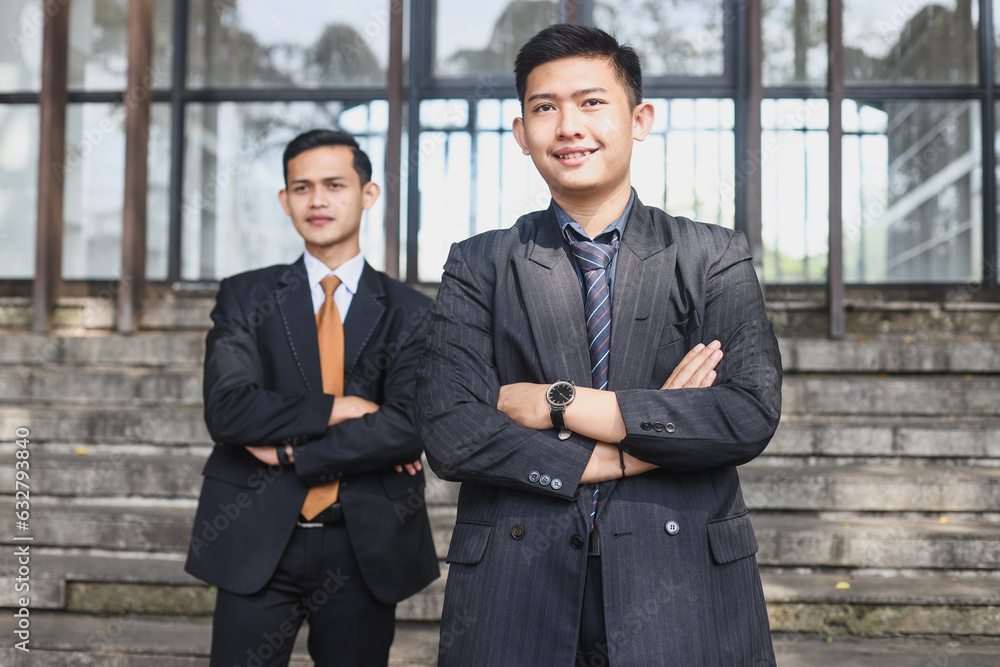 Young Asian business men smiling and looking at camera standing outside the office Young Asian business men smiling and looking at camera standing outside the office