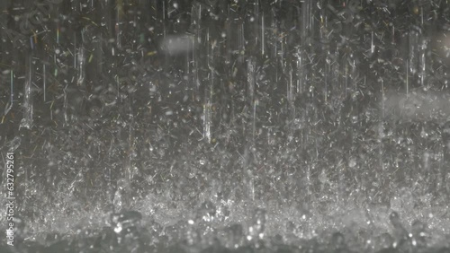 waterdrops falling in slow motion medium close-up, heavy rain raindrops splashing, gushing water in slomo, water droplets crashing down.