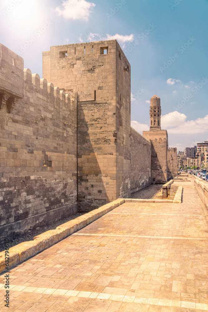 Old city walls with Minaret of Al-Hakim Mosque in Islamic Cairo, Egypt