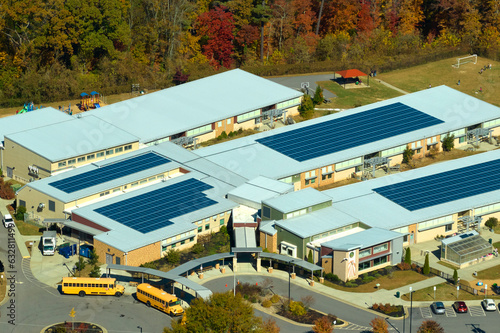 Aerial view of american school building with rooftop covered with photovoltaic solar panels for production of electric energy