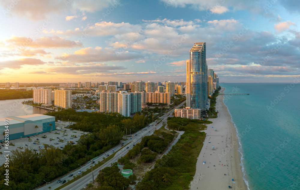 Naklejka premium View from above of luxurious highrise hotels and condos on Atlantic ocean shore in Sunny Isles Beach city in the evening. American tourism infrastructure in southern Florida