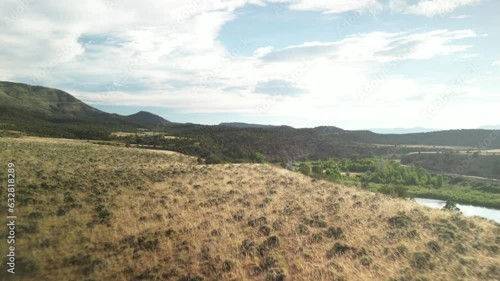 Aerial reveal of Colorado River off of grassy dry hillside in McCoy Colorado desert terrain in summer Aerial reveal of Colorado River off of grassy dry hillside in McCoy Colorado desert terrain in summer